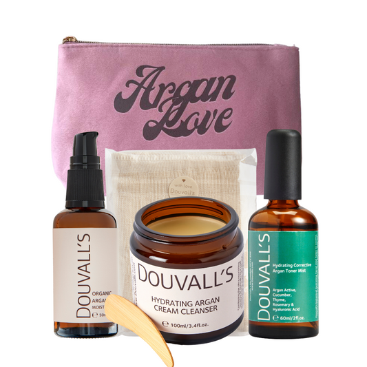 Skincare gift set with pink pouch, two argan bottles, and argan cream jar.